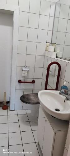 a white bathroom with a sink and a toilet at Große Monteurwohnung André bei Würzburg bis 6 Personen mit eigenen gratis Parklätzen und Grill und WLAN 3x Schlafzimmer - nur Einzelbetten in Veitshöchheim
