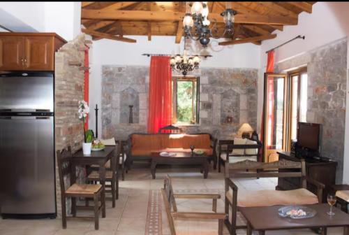 una sala de estar con mesas y sillas de madera. en Lithi Villa, en Neokhórion