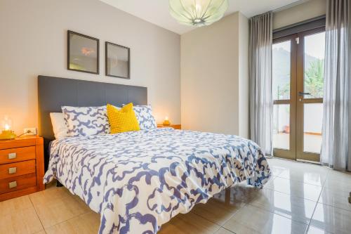 a bedroom with a bed with a blue and white comforter at Cozzy Carolina III in Adeje