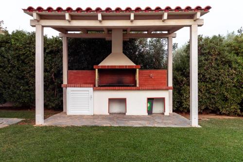 a small dog house with a red roof at Oceana - Exclusive Beachfront Villa with Private Pool and BBQ by GG in Alexandroupoli