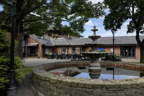 a fountain in the middle of a stone wall at Holiday Inn - Manchester - Oldham by IHG in Manchester