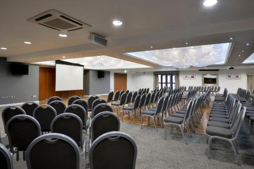 a conference room with chairs and a screen at Holiday Inn - Manchester - Oldham by IHG in Manchester