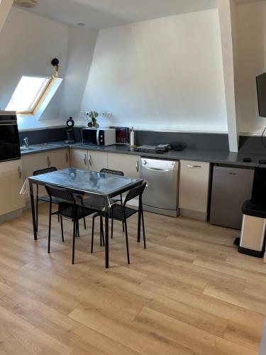 une cuisine avec une table et des chaises dans une pièce dans l'établissement Appartement Merlimont Plage, à Merlimont