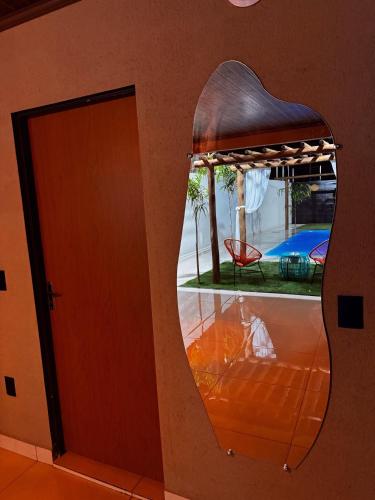 a mirror in a room with a bed and a pool at Villa Oásis Espaço para eventos in Anápolis