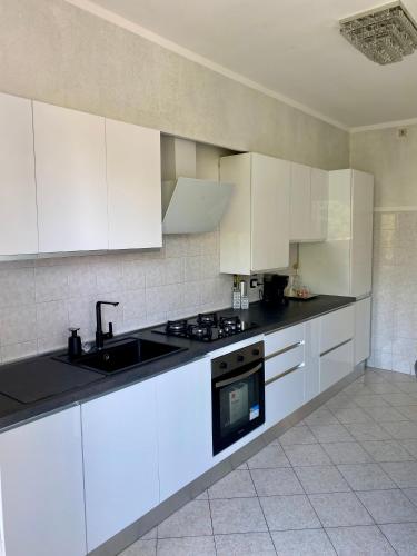 a kitchen with white cabinets and a sink at Appartamento Jaris in Vicenza