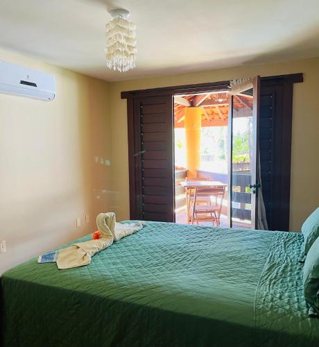 a bedroom with a bed with a green bedspread at Kite Bistro in Caucaia