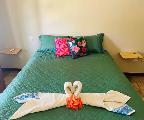 a green bed with a pair of towels on it at Kite Bistro in Caucaia
