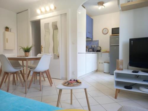une cuisine et un salon avec une table et des chaises dans l'établissement Adorable studio à 200m de la mer , frais , bien équipé et proche des commodités, à Cagnes-sur-Mer