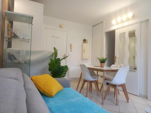 un salon avec un canapé, une table et des chaises dans l'établissement Adorable studio à 200m de la mer , frais , bien équipé et proche des commodités, à Cagnes-sur-Mer