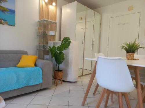 un salon avec un canapé et une table dans l'établissement Adorable studio à 200m de la mer , frais , bien équipé et proche des commodités, à Cagnes-sur-Mer
