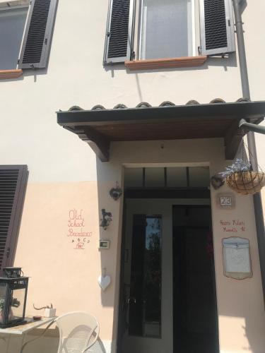 a white building with a door and a window at Old school Bacedasco B&B in Vernasca