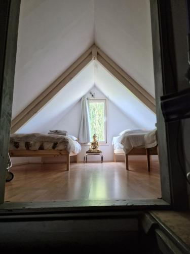 a attic room with two beds and a window at Amsterdam Millgreen Den Ilp 198 in Den Ilp