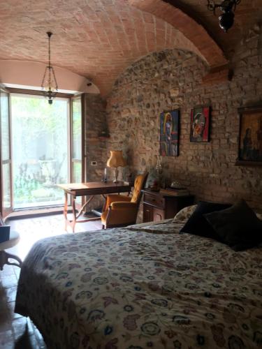 a bedroom with a bed and a table and a window at Old school Bacedasco B&B in Vernasca