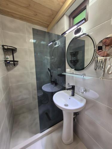 ein Badezimmer mit Waschbecken und Spiegel in der Unterkunft Guest House Okropilauri in Shuakhevi