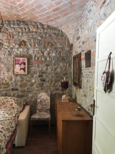 a bedroom with a bed and a table and a chair at Old school Bacedasco B&B in Vernasca
