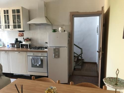 a kitchen with a white refrigerator and a table at Old school Bacedasco B&B in Vernasca