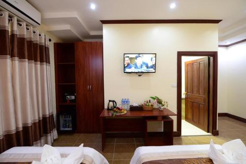 a bedroom with two beds and a television on the wall at Vientiane Luxury Hotel in Vientiane