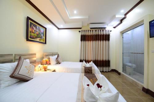 a hotel room with two beds and a window at Vientiane Luxury Hotel in Vientiane