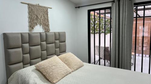 a bedroom with a large bed and a large window at Lindos Apartamentos con Terraza in Manizales