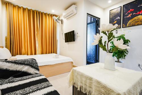 a room with two beds and a vase with flowers at Shi House - Studios S503 Cozy Beautiful Vinhomes in Long Bình