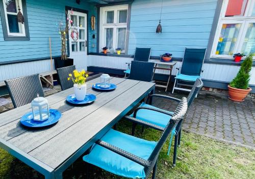 a wooden table with blue plates and chairs on a patio at Villa Blue Heaven Pärnu in Pärnu