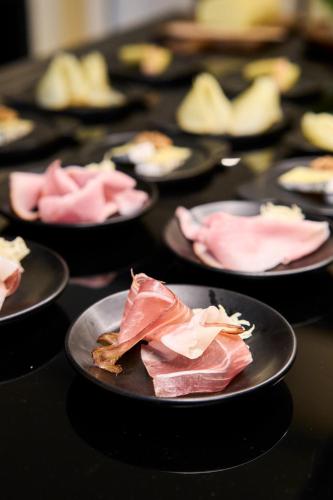 a row of black plates of food on a table at Henriette Stadthotel Vienna in Vienna