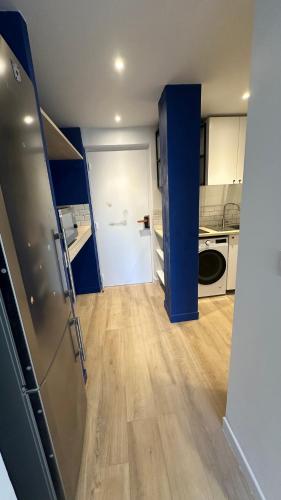 Il comprend une cuisine dotée d'un réfrigérateur et d'un mur bleu. dans l'établissement Lyon Tassin appartement proche Métro bus parking possible, à Vaise