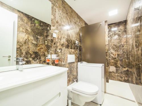 a bathroom with a toilet and a sink and a mirror at Luxury Apartment Valentina in Budva