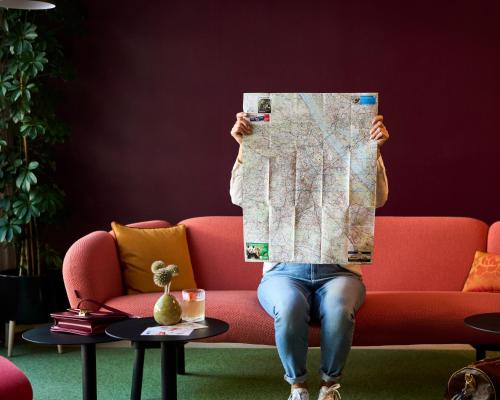 a person sitting on a couch holding a map at Henriette Stadthotel Vienna in Vienna