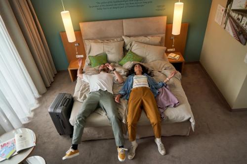 a couple of people laying on a bed at Henriette Stadthotel Vienna in Vienna