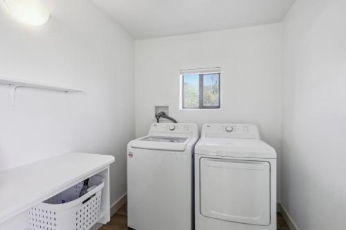 a laundry room with two washing machines and a window at The Grand Horizon in Vail