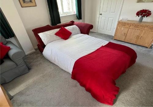 a bedroom with a bed with a red blanket on it at Character House for Buisness, Holidays and Relocation in Frinton-on-Sea