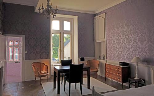une salle à manger avec des murs violets, une table et des chaises dans l'établissement Château d'Argoules, Baie de Somme près de la mer, à Argoules