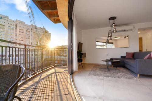 a living room with a couch and a balcony at Deluxe 1 Bedrooms Apartment Terrace in City Center in Jerusalem