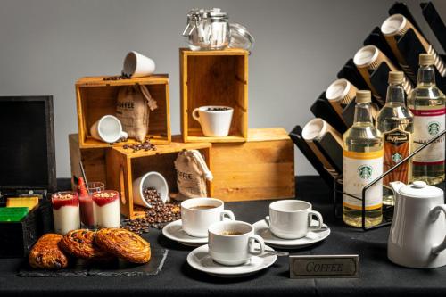 a table with cups of coffee and croissants on it at Holiday Inn - Manchester - Oldham by IHG in Manchester