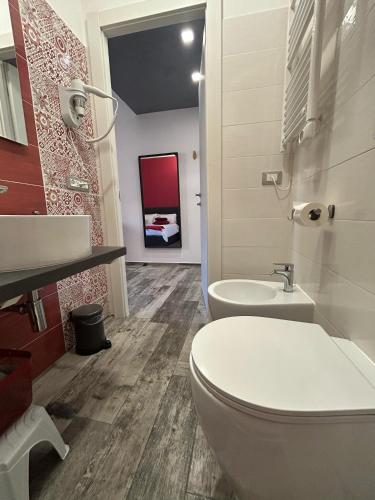 a bathroom with a toilet and a sink at Rosso Relativo in Acilia