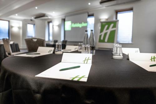 a conference room with a black table with papers and a pen at Holiday Inn - Manchester - Oldham by IHG in Manchester