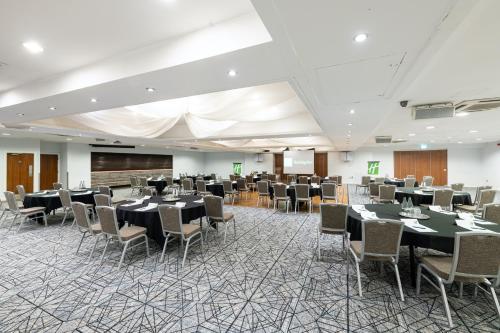 a conference room with tables and chairs and a podium at Holiday Inn - Manchester - Oldham by IHG in Manchester