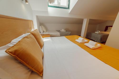 a bedroom with a large bed with two towels on it at Rossio Suites By Hosty in Lisbon
