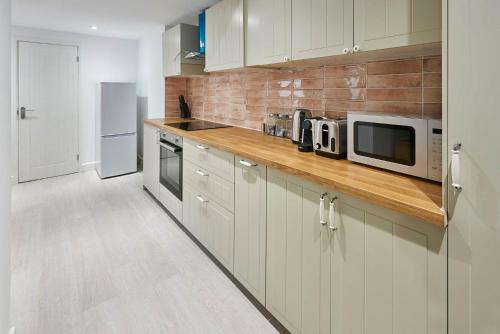 Una cocina con gabinetes blancos y un microondas. en Host & Stay - Blatchington Road, en Brighton & Hove