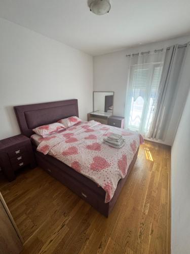 ein Schlafzimmer mit Bett, Schreibtisch und Fenster in der Unterkunft City Apartment in Podgorica