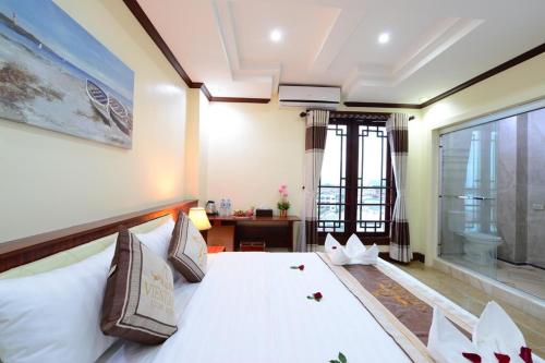 a bedroom with a large white bed and a window at Vientiane Luxury Hotel in Vientiane