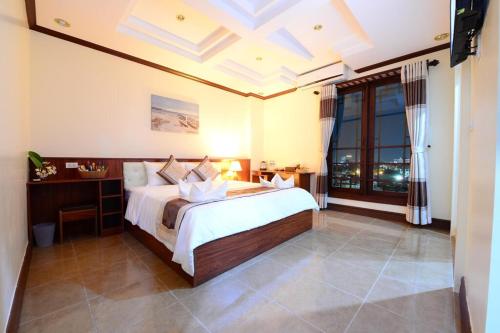 a bedroom with a large bed and a large window at Vientiane Luxury Hotel in Vientiane