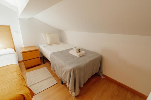 a small room with two beds and a table at Rossio Suites By Hosty in Lisbon
