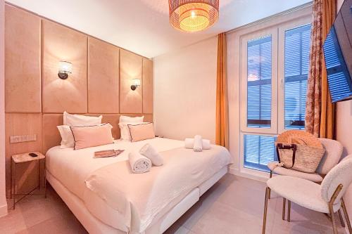 une chambre avec un lit, une chaise et une fenêtre dans l'établissement Idéal Appartement sur le Port - VIP, à Saint-Tropez