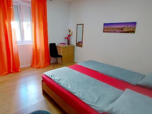 a bedroom with a bed and a dresser with orange curtains at Ema & Sea Apartment's in Pula