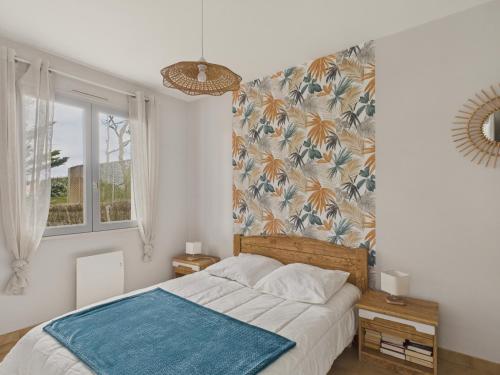 une chambre avec un lit avec une couverture bleue dans l'établissement 150m de la plage - Maison vendéenne pour 6, à Bretignolles-sur-Mer