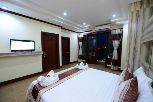 a bedroom with a large bed and a flat screen tv at Vientiane Luxury Hotel in Vientiane