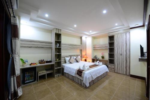 a bedroom with a large bed and a fireplace at Vientiane Luxury Hotel in Vientiane