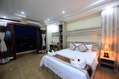 a bedroom with a large bed and a large window at Vientiane Luxury Hotel in Vientiane